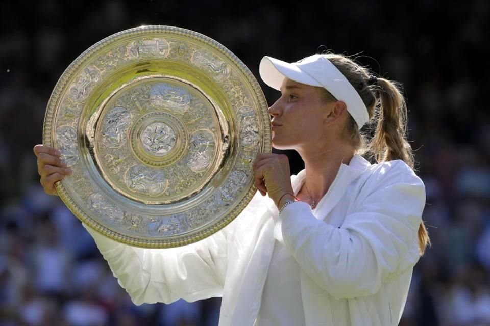 Elena Rybakina sellando su conquista de Wimbledon al besar el mítico trofeo.