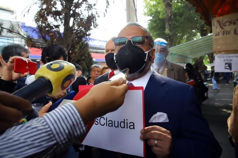 Regino sostuvo un letrero con el hashtag #esClaudia. 