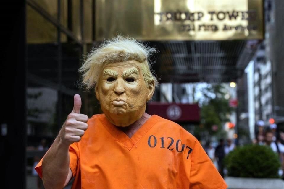 Una manifestante disfrazado del ex Presidente de EU Donald Trump con ropa de preso posa para fotos afuera de la Torre Trump en Nueva York.