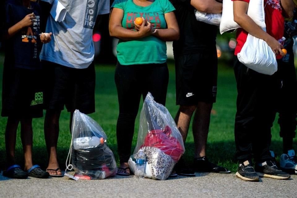 Migrantes que fueron llevados en autobús de Texas a Washington D.C. el 11 de agosto escuchan a voluntarios que les ofrecen asistencia.