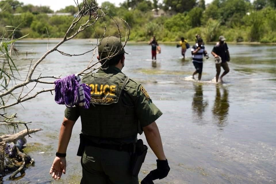Un agente de la Patrulla Fronteriza observa a un grupo de migrantes que cruzan el Río Bravo para entregarse a las autoridades en Del Río, Texas, en junio del año pasado.