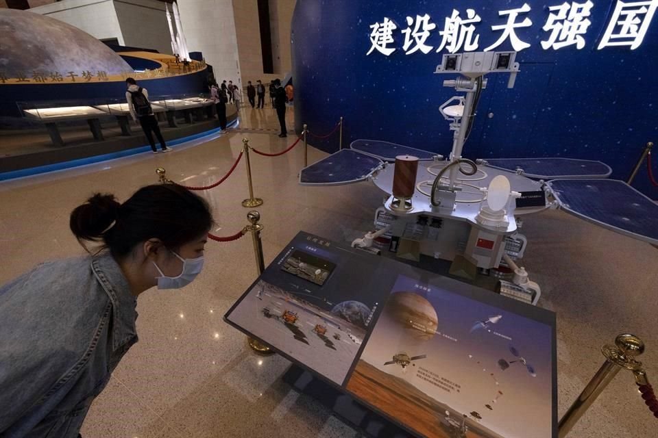 Una mujer visita la exhibición del programa espacial chino en la que se ve un modelo de tamaño real del rover chino Zhurong.