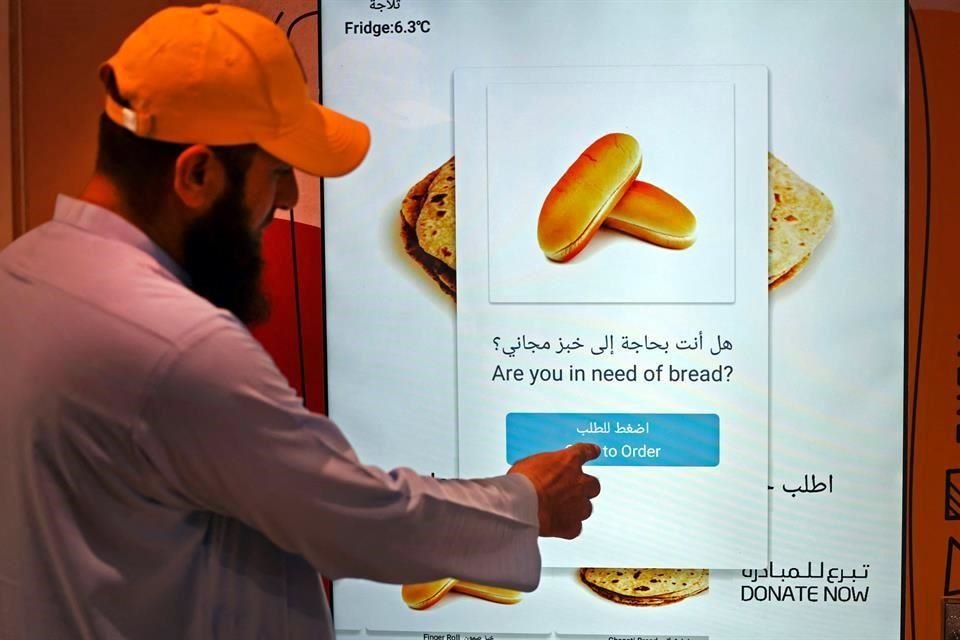 Un hombre utiliza la máquina dispensadora de pan gratuito en Dubái.