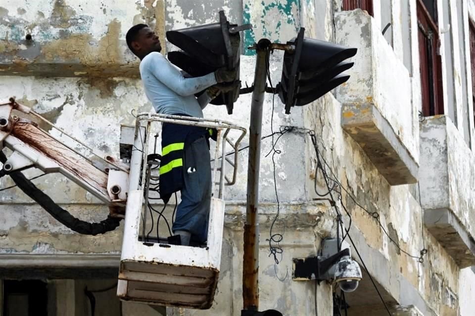 Un hombre trabaja para reparar un semáforo en La Habana.