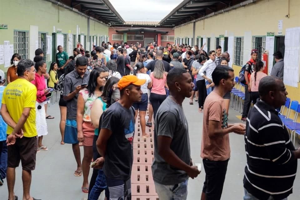 Personas hacen fila en  Brasilia para emitir su voto este domingo.
