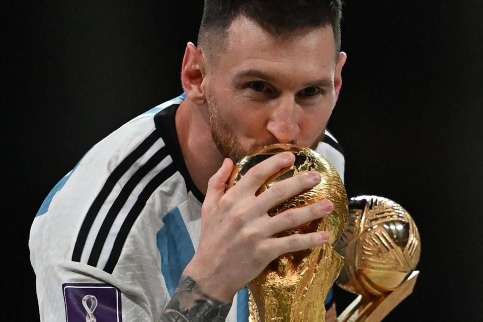 Argentina's captain and forward #10 Lionel Messi kisses the FIFA World Cup Trophy.
