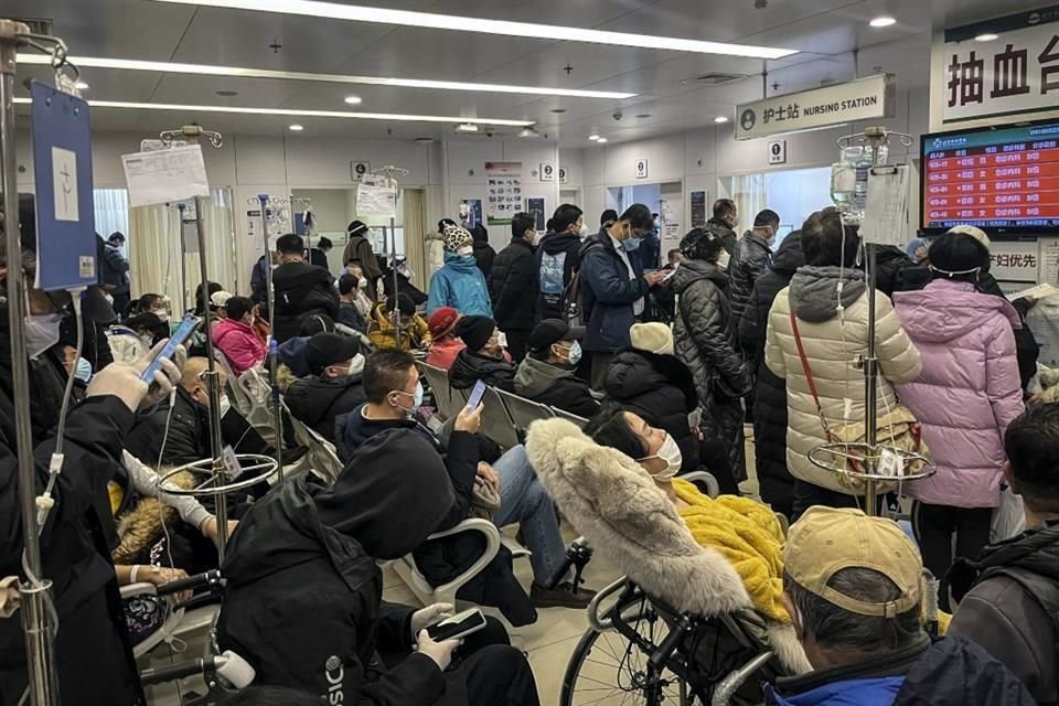 Pacientes en sillas de ruedas y personas en el departamento de emergencias de un hospital en Beijing.