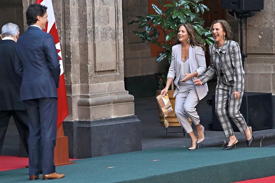 Sophie Grégoire y Beatriz Gutiérrez corren para alcanzar a sus esposos durante la reunión bilateral México-Canadá que se efectuó ayer en Palacio Nacional.
