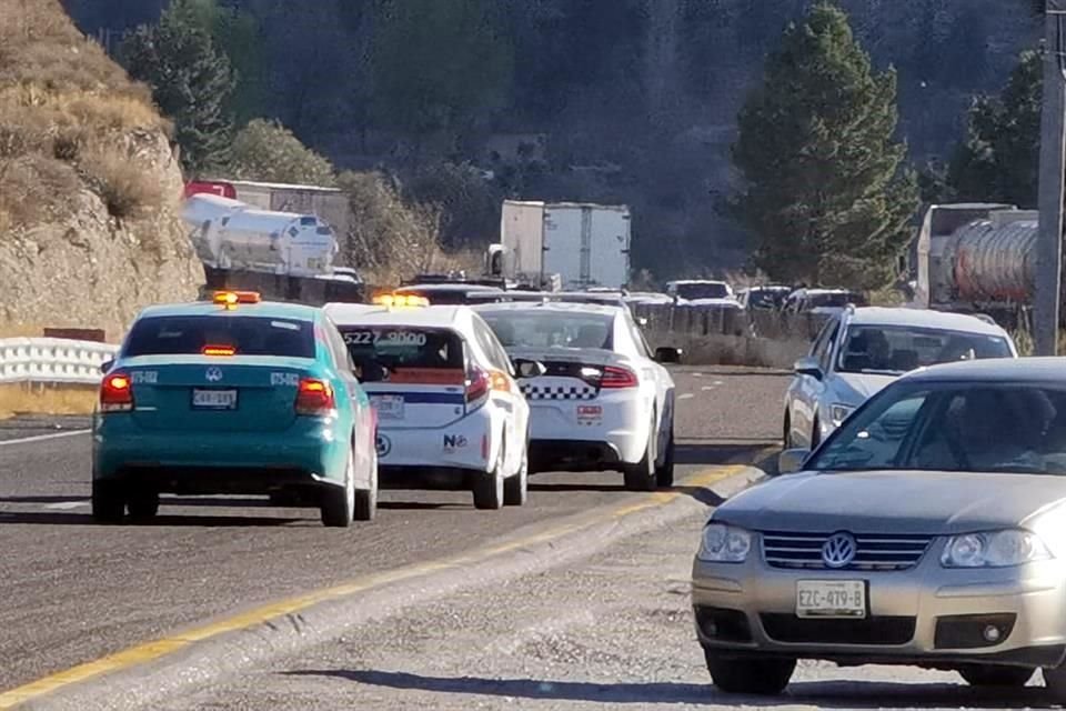 Agentes de la Guardia Nacional división Carreteras escoltan en carril contrario de circulación a dos vehículos de seguros, que atienden accidente en Los Chorros.