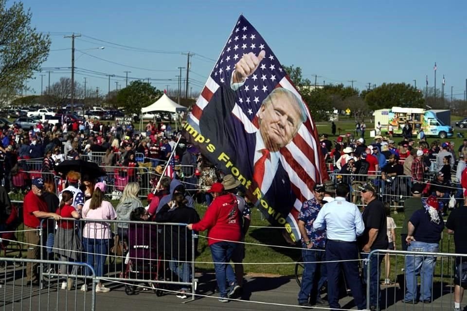 Una gran bandera luce la imagen de Trump mientras la gente se reúne en el Aeropuerto Regional de Waco antes del acto de campaña.