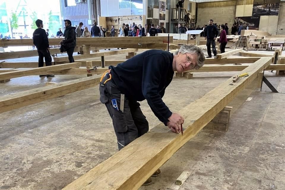 Peter Henrikson, un carpintero de 61 años de Minnesota, mide una viga que formará parte de la estructura del nuevo tejado de la catedral de Notre Dame.