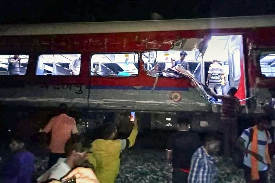 La gente inspecciona el sitio de los trenes de pasajeros que descarrilaron en el distrito de Balasore.