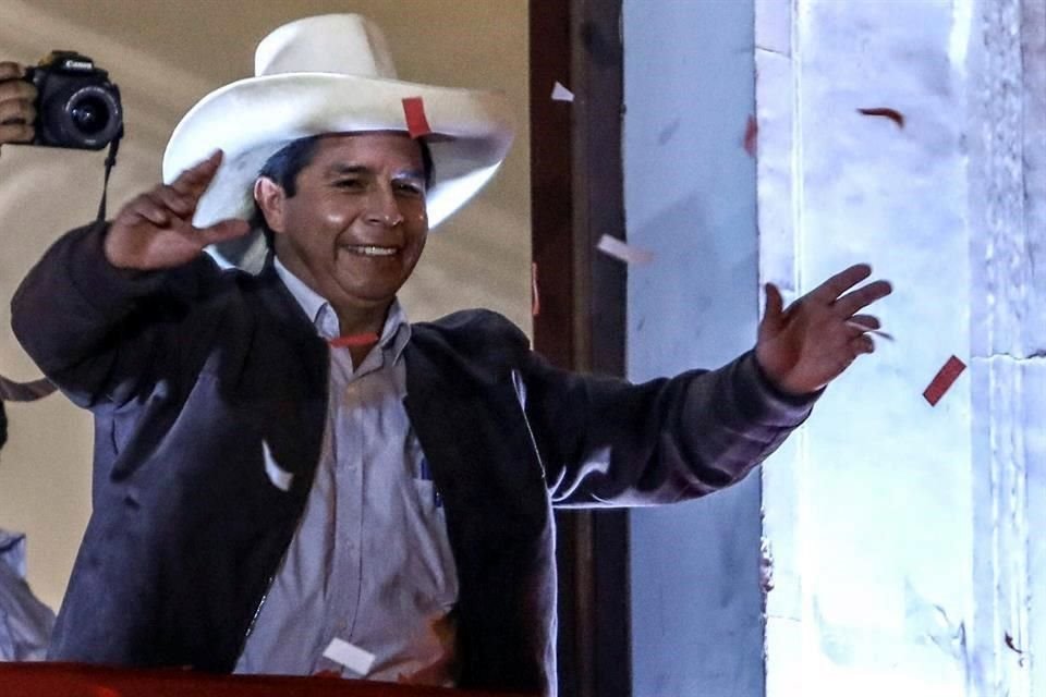 El candidato presidencial peruano Pedro Castillo saluda a sus seguidores en el balcón de la sede central de su partido, en Lima.
