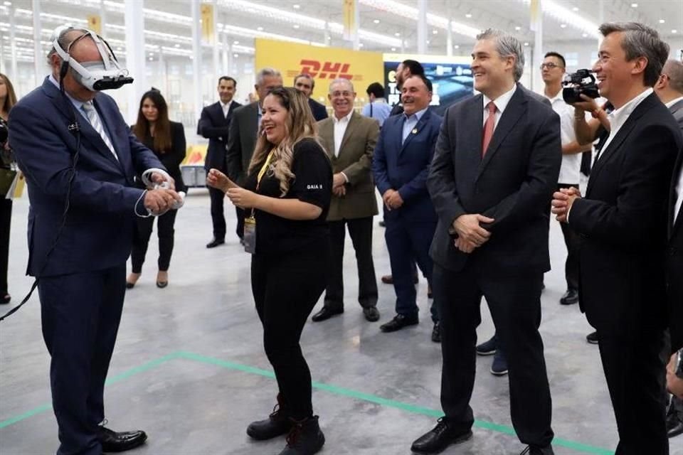 Con lentes de realidad virtual, Javier Navarro, Secretario de Gobierno de NL, observado por Iván Rivas, Secretario de Economía, y Agustín Croche, CEO de DHL Supply Chain para América Latina.
