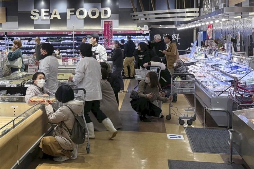 Los clientes se agachan tras un terremoto en un supermercado en Toyama, Japón, el domingo 1 de enero de 2024.