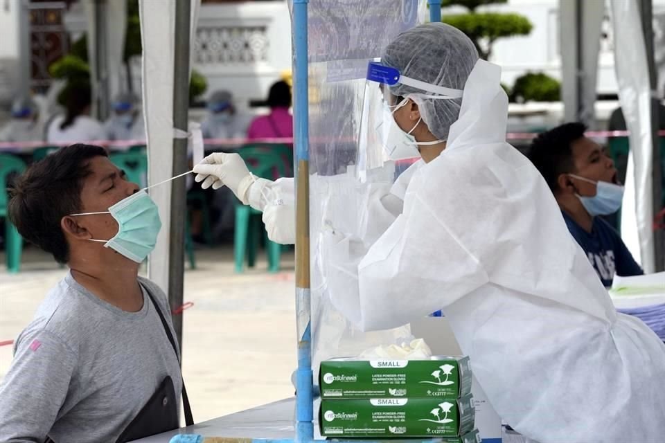 Un trabajador de salud recolecta una muestra para una prueba de Covid-19, en Tailandia.