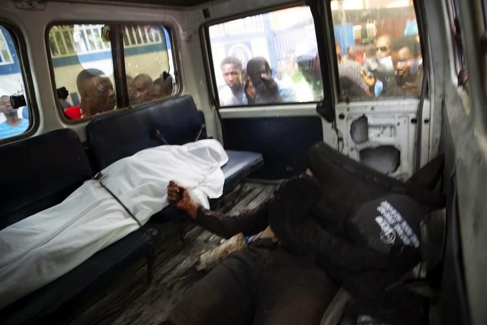 Personas en Haití miran a los cadáveres dentro de un vehículo de la Policía. Los hombres, presuntamente, eran responsables del asesinato del presidente.