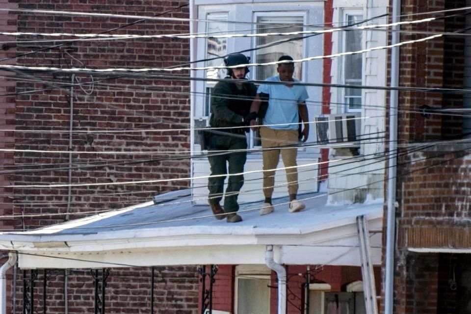 La Policía saca a personas de una casa en Trenton, Nueva Jersey.