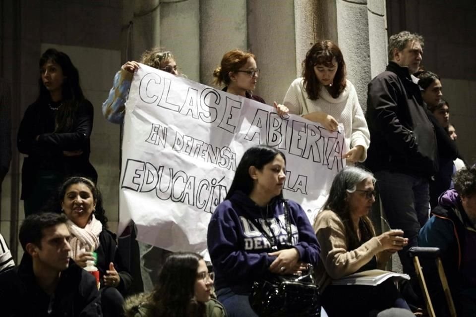 Estudiantes sostienen un cartel que dice 'Clase abierta en defensa de la educación pública' en las escaleras de la facultad de derecho de la Universidad de Buenos Aires para protestar contra Milei.