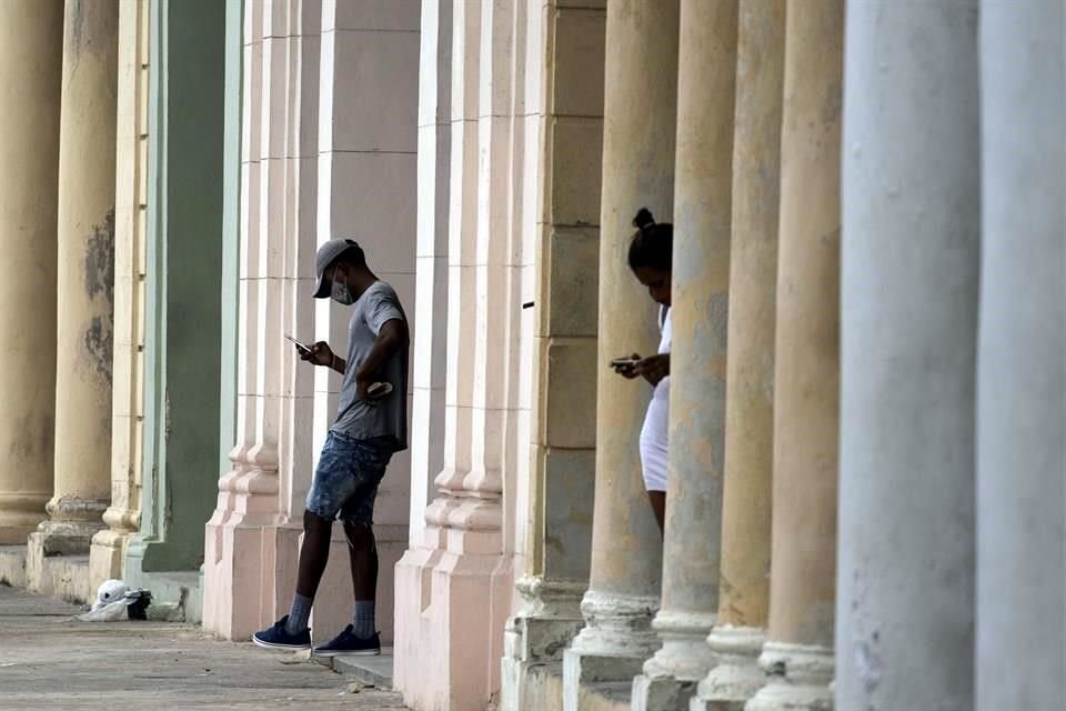 Personas buscan conexión a una red de WiFi en La Habana, Cuba.