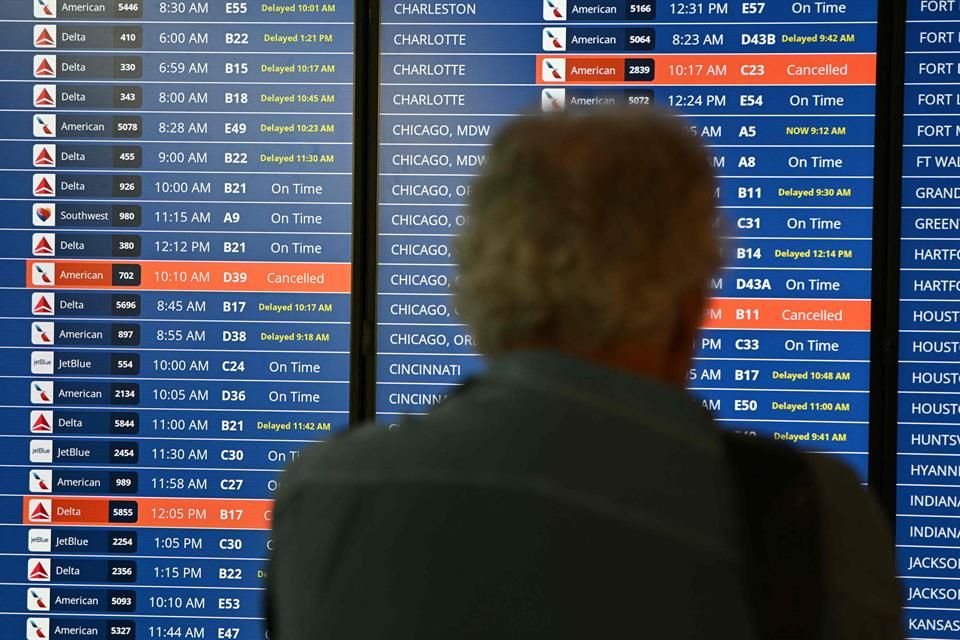 Un monitor muestra vuelos cancelados y retrasados ​​en el Aeropuerto Nacional Ronald Reagan de Washington por el apagón global.