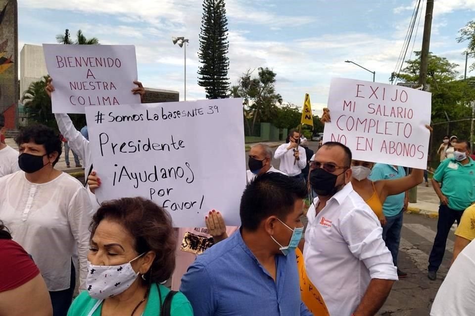 Trabajadores y pensionados afectados en Colima protestan a las afueras del evento del Presidente López Obrador.