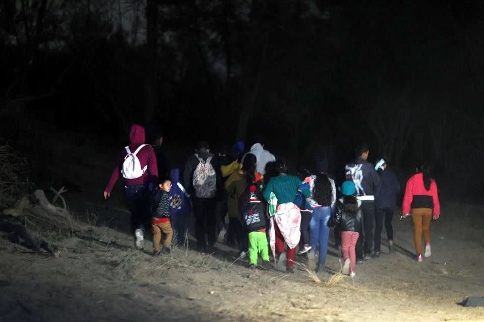 Un grupo de migrantes camina cerca de la frontera sur de EU para entrar ilegalmente al país.