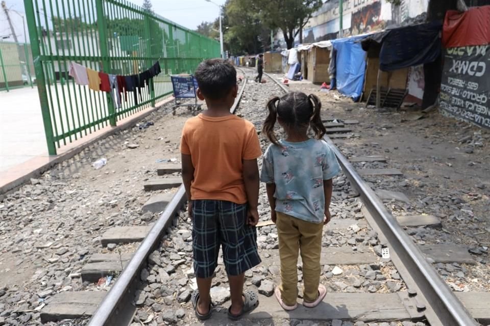 Menores, provenientes en su mayoría de las caravanas salieron de los cuartos de madera improvisados a recibir juguetes y hamburguesas que policías y ciudadanos acudieron a repartirles.