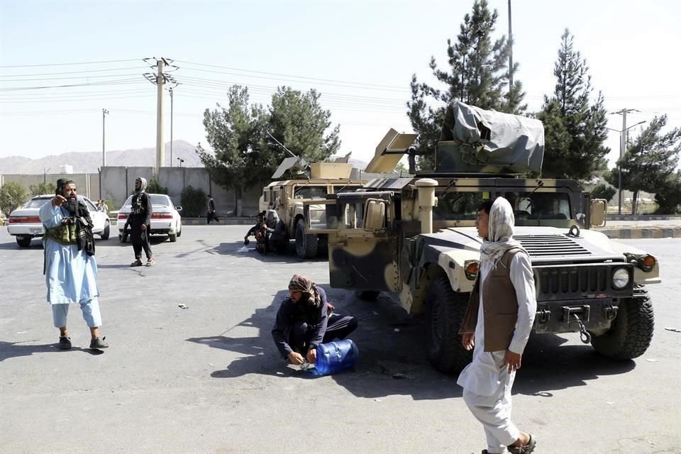 Combatientes talibanes hacen guardia afuera del aeropuerto de Kabul, luego de los mortales ataques de una rama del Estado islámico.