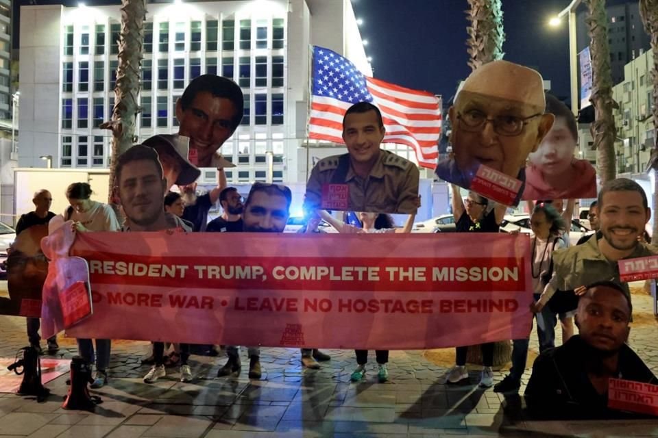 Personas sostienen retratos de rehenes cuyo restos siguen bajo custodia de Hamas, durante una protesta en Tel Aviv.
